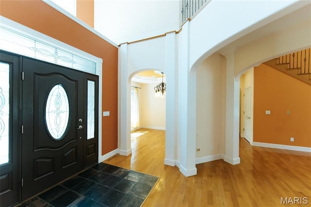 1025 Cobblestone Dr, Rolla, MO 65401 - foyer with light wood-style floors, arched walkways, baseboards, a towering ceiling, and a chandelier
