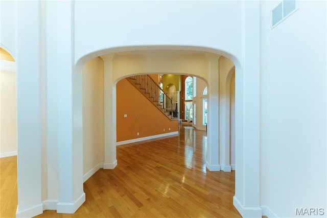 1025 Cobblestone Dr, Rolla, MO 65401 - corridor featuring light wood-type flooring, stairs, arched walkways, and baseboards