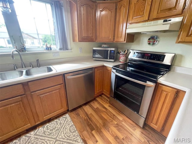 11652 Two Mile Rd, Dexter, MO 63841 - kitchen featuring appliances with stainless steel finishes, under cabinet range hood, light countertops, and brown cabinetry