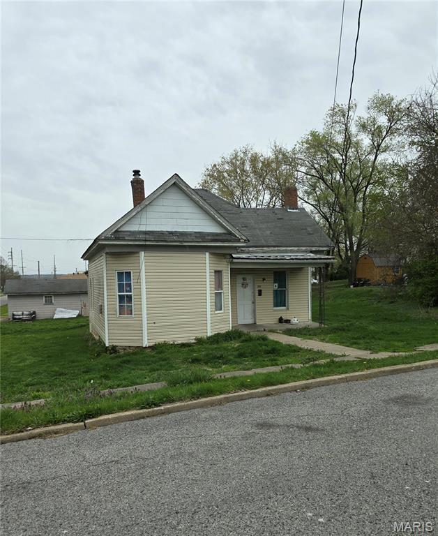 109 S 6th St, Elsberry, MO 63343 - view of front of home featuring a chimney and a front yard