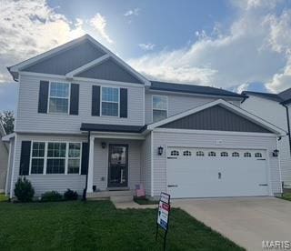 view of front of house with an attached garage, concrete driveway, and a front yard