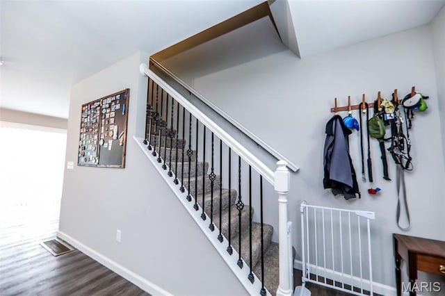 stairway with wood finished floors and baseboards