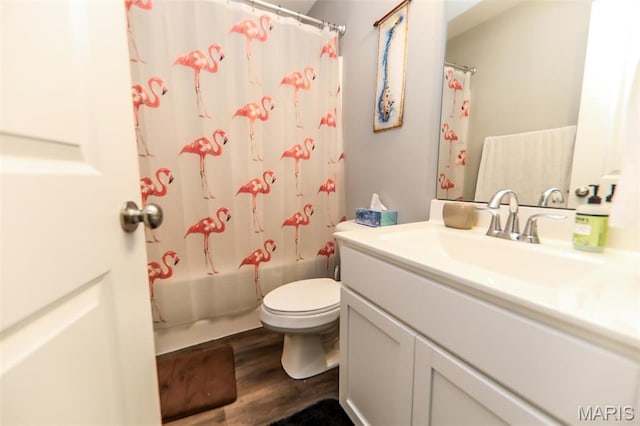 bathroom with toilet, wood finished floors, vanity, and shower / bath combo with shower curtain