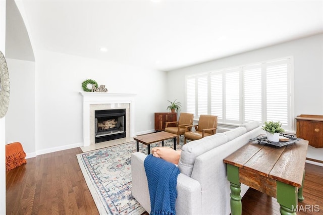 living room featuring wood finished floors, a high end fireplace, baseboards, and recessed lighting