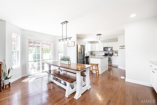 dining area featuring hardwood / wood-style floors, baseboards, and recessed lighting
