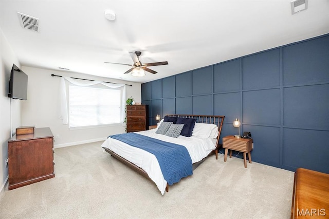 bedroom featuring a decorative wall, carpet flooring, ceiling fan, and baseboards