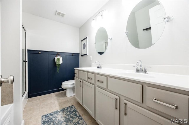 full bathroom with toilet, double vanity, a shower with shower door, and tile patterned floors