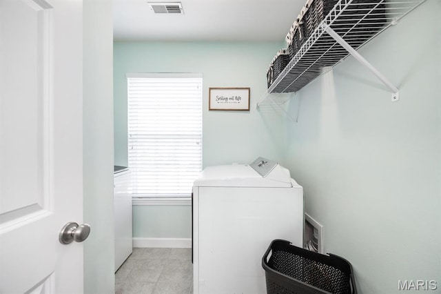 washroom featuring separate washer and dryer, baseboards, and light tile patterned floors