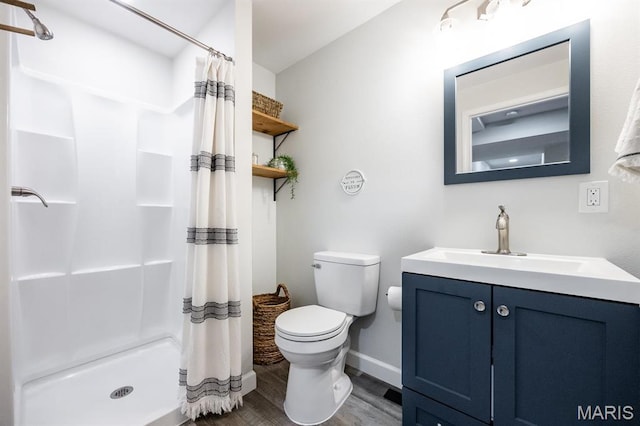 full bath featuring wood finished floors, toilet, baseboards, a shower stall, and vanity