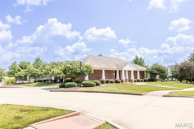 view of front of property featuring a front yard and curved driveway