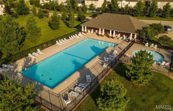 community pool featuring fence and a patio area