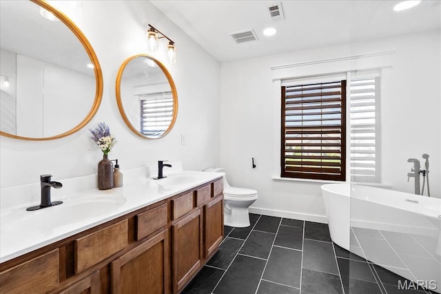 6 Bradley Ct, Troy, IL 62294 - bathroom with a soaking tub, double vanity, toilet, tile patterned flooring, and baseboards