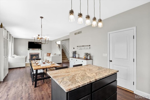 6 Bradley Ct, Troy, IL 62294 - kitchen with dark cabinetry, a brick fireplace, dark wood finished floors, decorative light fixtures, and a center island