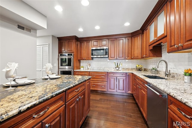 585 Coeur De Royale Dr Unit 203, Creve Coeur, MO 63141 - kitchen with stainless steel appliances, light stone counters, dark wood-type flooring, glass insert cabinets, and decorative backsplash