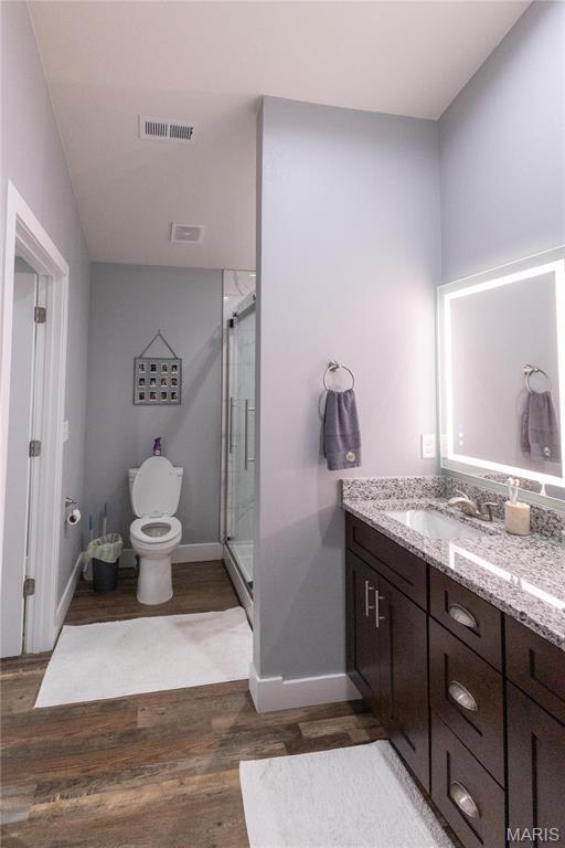159 Mesa Dr, Waynesville, MO 65583 - bathroom with toilet, wood finished floors, a stall shower, vanity, and baseboards