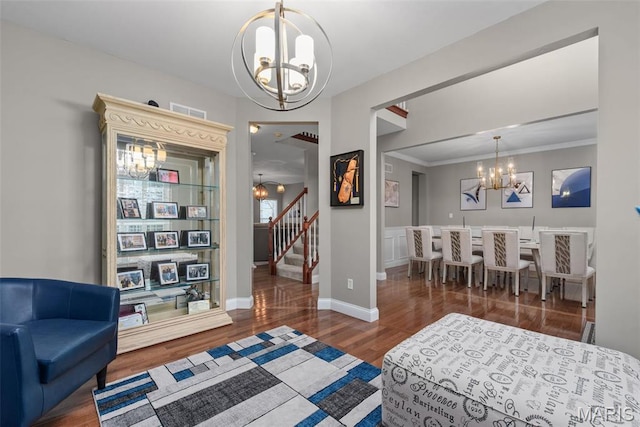 bedroom with a chandelier, wood finished floors, baseboards, and crown molding