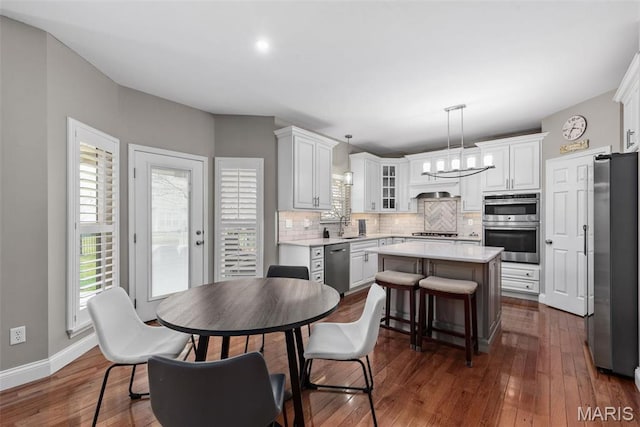 dining room with dark wood-type flooring, baseboards, and a chandelier