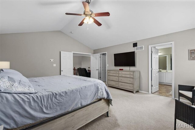 bedroom with lofted ceiling, light carpet, ceiling fan, ensuite bathroom, and baseboards