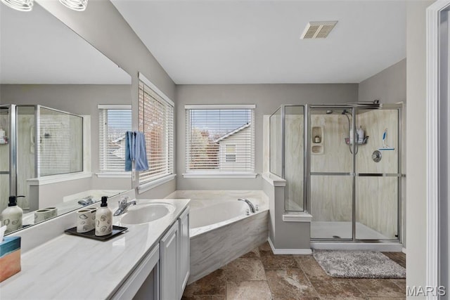 bathroom featuring a shower stall, a garden tub, and vanity