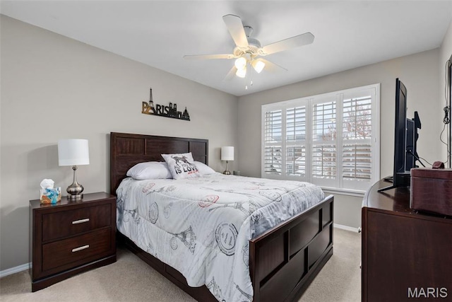 bedroom with light colored carpet, baseboards, and a ceiling fan