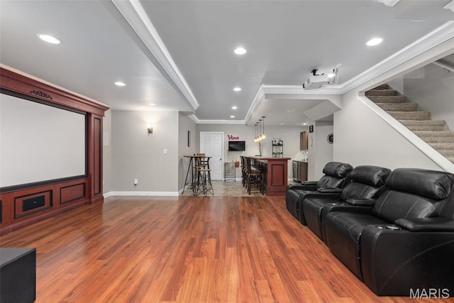 home theater with a dry bar, wood finished floors, crown molding, recessed lighting, and baseboards