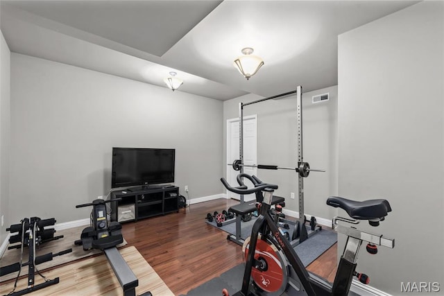 workout area featuring baseboards and wood finished floors