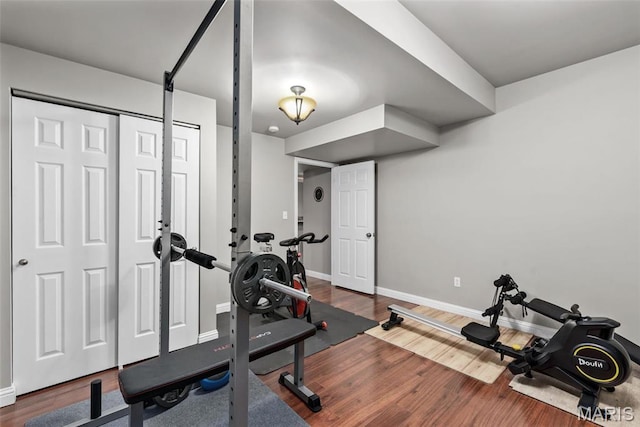 workout area with baseboards and wood finished floors