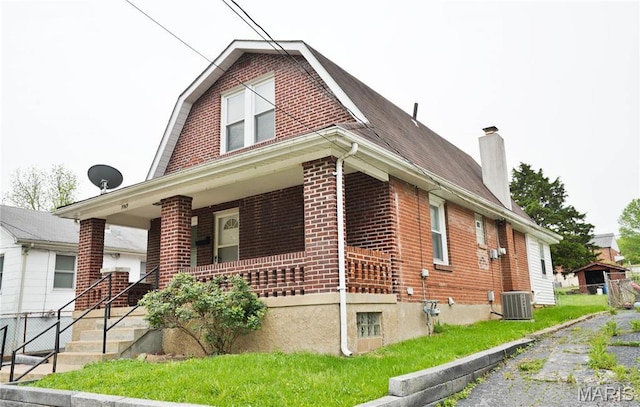 9969 Lark Ave, Saint Louis, MO 63125 - view of home's exterior with brick siding, covered porch, a chimney, and a gambrel roof