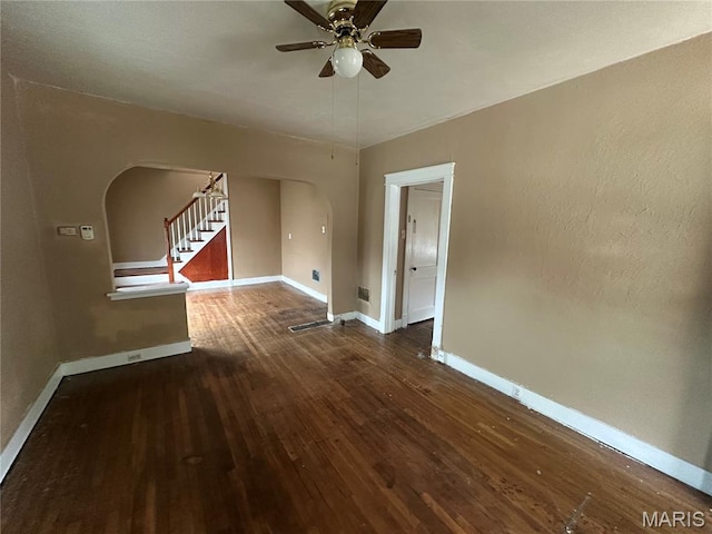 9969 Lark Ave, Saint Louis, MO 63125 - spare room featuring arched walkways, wood finished floors, ceiling fan, and stairway