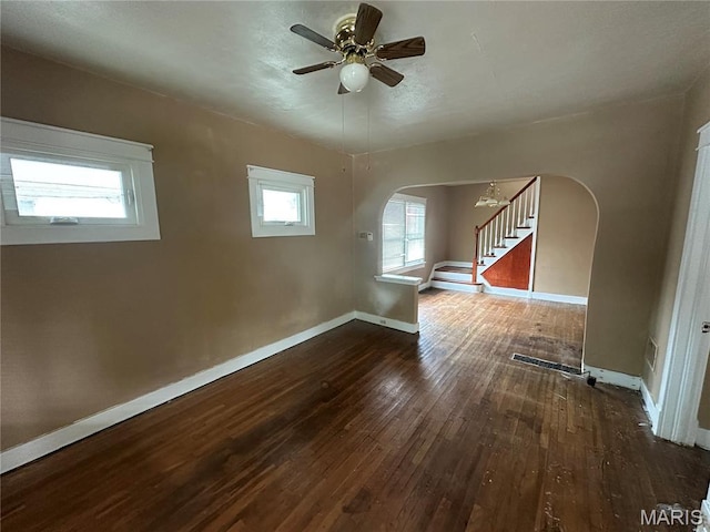 9969 Lark Ave, Saint Louis, MO 63125 - unfurnished room featuring arched walkways, wood-type flooring, ceiling fan, and stairway