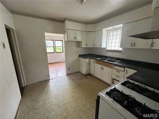 9969 Lark Ave, Saint Louis, MO 63125 - kitchen with wall chimney range hood, plenty of natural light, white gas range oven, and dark countertops