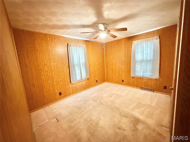 815 Stewart St, De Soto, MO 63020 - empty room featuring plenty of natural light, ceiling fan, wood walls, light carpet, and baseboards
