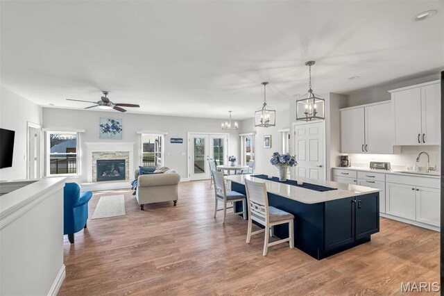 116 Dardenne Place Dr, Dardenne Prairie, MO 63368 - kitchen with a sink, a center island, white cabinets, and a kitchen bar