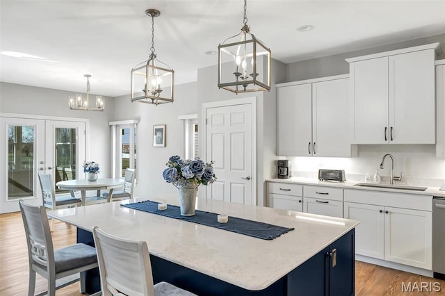 116 Dardenne Place Dr, Dardenne Prairie, MO 63368 - kitchen with a sink, a kitchen island, a chandelier, french doors, and light wood-type flooring