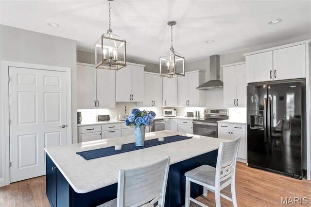 116 Dardenne Place Dr, Dardenne Prairie, MO 63368 - kitchen with appliances with stainless steel finishes, wall chimney range hood, a center island, a chandelier, and decorative light fixtures
