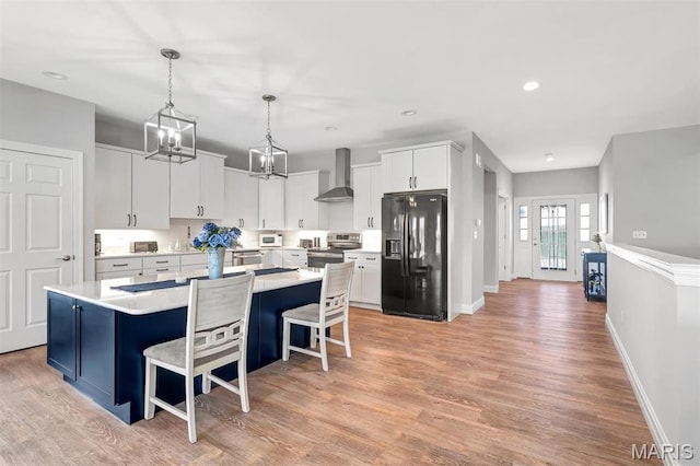 116 Dardenne Place Dr, Dardenne Prairie, MO 63368 - kitchen with black refrigerator with ice dispenser, wall chimney exhaust hood, stainless steel electric stove, a center island, and light countertops