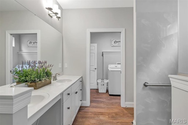 116 Dardenne Place Dr, Dardenne Prairie, MO 63368 - bathroom featuring washer / dryer, wood finished floors, double vanity, and baseboards