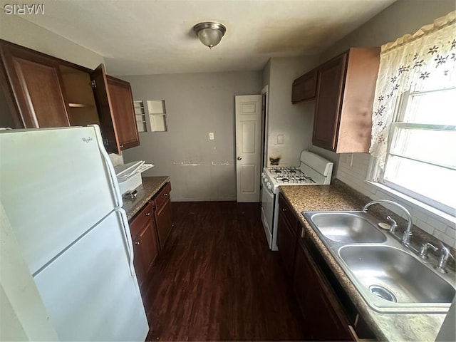 737 Charbonier Rd, Florissant, MO 63031 - kitchen featuring white appliances, a sink, dark wood-style floors, and dark countertops