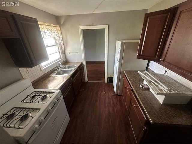 737 Charbonier Rd, Florissant, MO 63031 - kitchen featuring white gas range, a sink, dark wood-style flooring, and tasteful backsplash