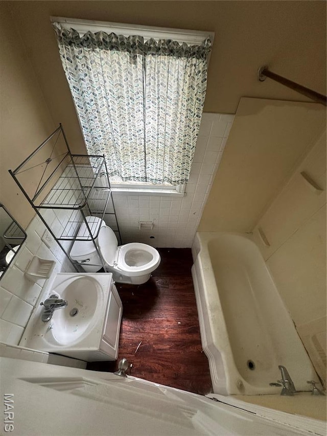 737 Charbonier Rd, Florissant, MO 63031 - full bath featuring a tub, wood finished floors, toilet, and a sink