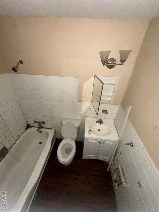 737 Charbonier Rd, Florissant, MO 63031 - full bathroom with tile walls, wood finished floors, a wainscoted wall, a tub, and vanity