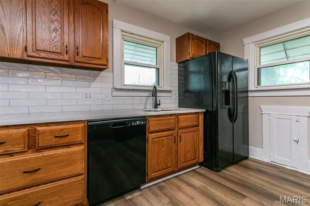 514 Hamilton Ave, Wood River, IL 62095 - kitchen featuring black appliances, brown cabinetry, healthy amount of natural light, and wood finished floors