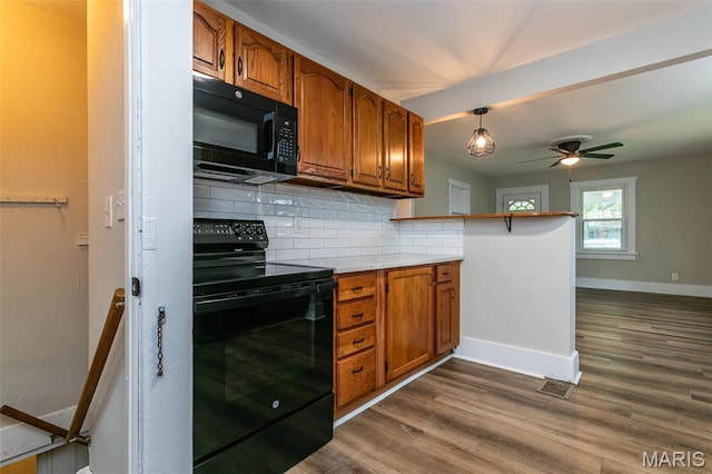 514 Hamilton Ave, Wood River, IL 62095 - kitchen featuring black appliances, backsplash, brown cabinets, and baseboards