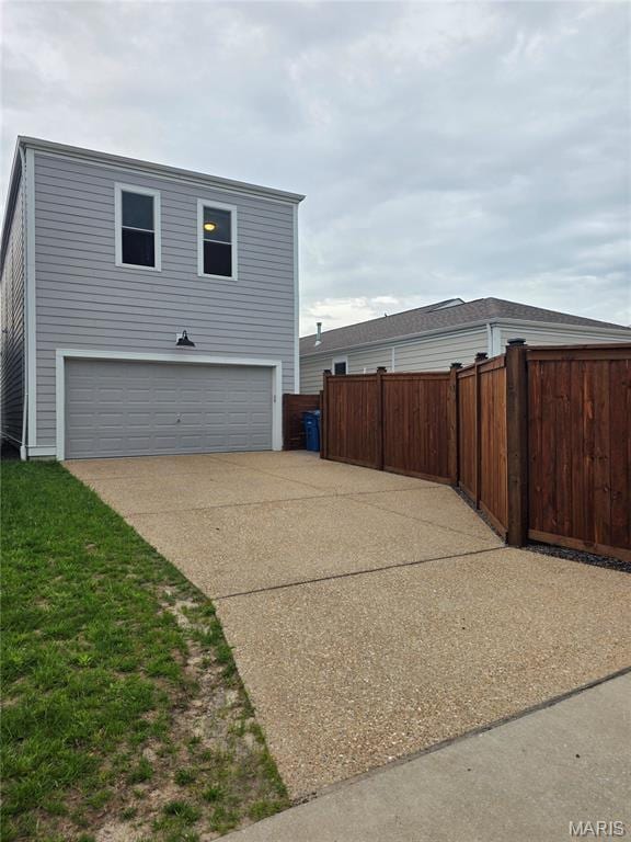 view of property exterior with fence and concrete driveway