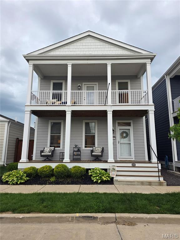 view of front of property with a balcony and covered porch