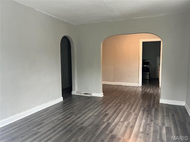 2123 Rosebud Ave, Hillsdale, MO 63121 - empty room with arched walkways, dark wood-type flooring, and baseboards