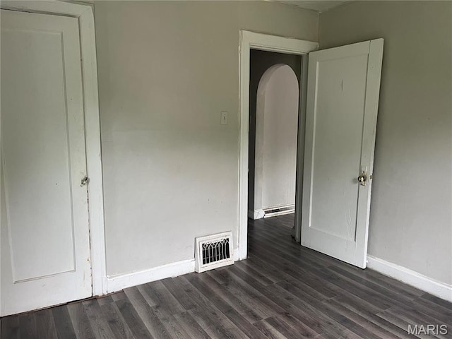2123 Rosebud Ave, Hillsdale, MO 63121 - unfurnished bedroom with baseboards, dark wood-type flooring, and arched walkways
