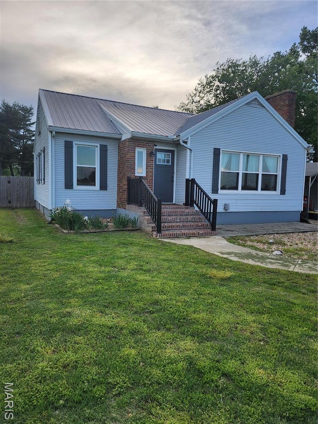 view of front of house featuring metal roof and a chimney