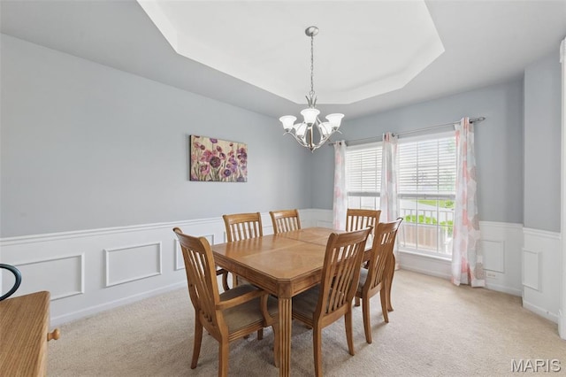65 Snowberry Ridge Ct, Ofallon, MO 63366 - dining area with a chandelier, a tray ceiling, a wainscoted wall, light carpet, and a decorative wall