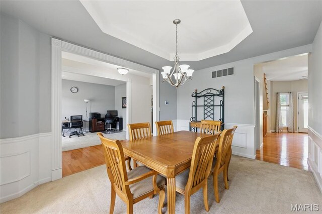 65 Snowberry Ridge Ct, Ofallon, MO 63366 - dining area with light colored carpet, a chandelier, a raised ceiling, an office area, and a wainscoted wall